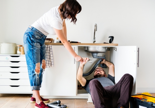 Man and woman repairing a sink