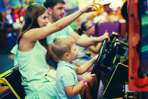 Small family having fun at the arcade